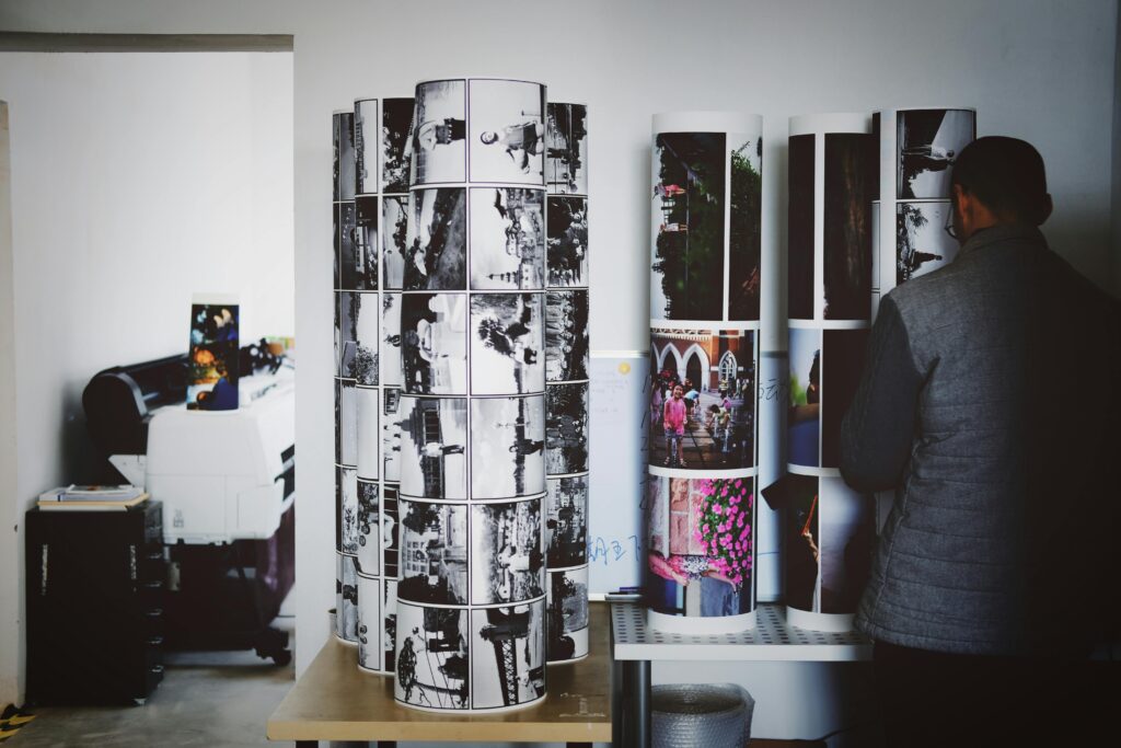 A man examines rolls of large format photos in a professional photography studio.