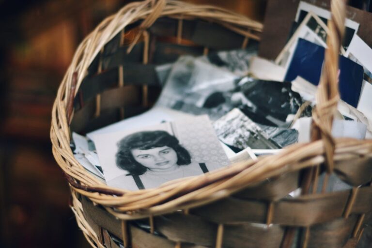 A collection of vintage black and white photos in a woven basket evokes nostalgia.