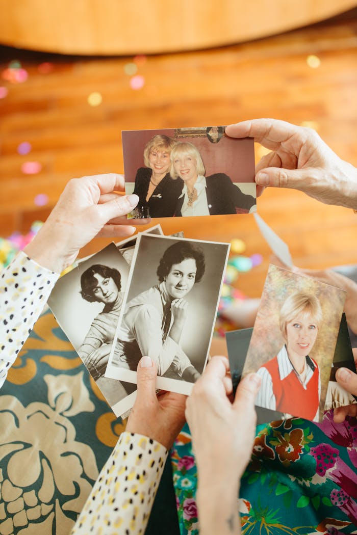 Adults reminiscing over vintage photos, capturing warm moments and memories.